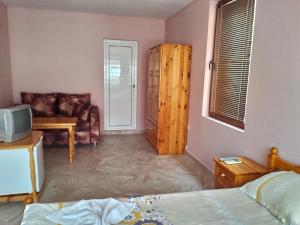 a bedroom with a bed and a couch and a television at Guest House Diamant in Sozopol +32 photos