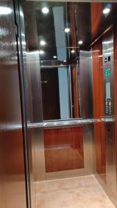 a stainless steel refrigerator with a mirror in a room at Hotel Rena in Agios Kirykos