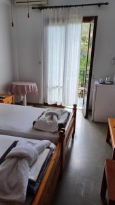 a bedroom with two beds and a large window at Hotel Rena in Agios Kirykos