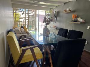 a dining room with a glass table and chairs at Cálido y acogedor departamento cerca del centro in Tlaxcala de Xicohténcatl