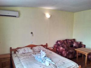 a bedroom with a bed and a couch and a chair at Guest House Diamant in Sozopol