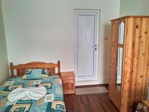 a bedroom with a bed and a dresser and a window at Guest House Diamant in Sozopol