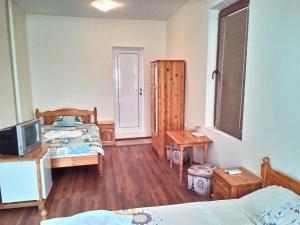 a bedroom with two beds and a television in it at Guest House Diamant in Sozopol