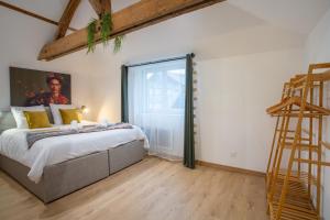 a bedroom with a bed and a large window at L'invention poétique - T2 charmant en Hyper centre in Abbeville