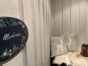 ein Zimmer mit zwei Kissen und einem Schild an der Wand in der Unterkunft Marvelous farmhouse with amazing fjord and mountain view in Northern Norway in Nordøya