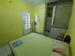 an empty room with a bed and a window at RD suítes 1 in Guarujá