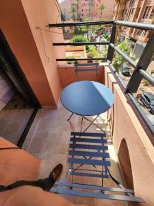 a person laying on a balcony with a table and chair at Luxury apartment in Gueliz, near the Majorelle Garden and Yves Saint Laurent Museum in Marrakech