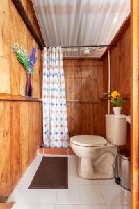 a bathroom with a toilet and a shower at Hermosa cabaña con vista al Embalse de Tomine in Guatavita