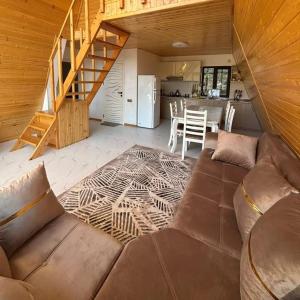 ein Wohnzimmer mit Couch und Küche in der Unterkunft Cozy house in the forest! in Qǝçrǝş