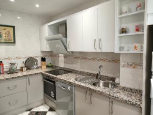 a kitchen with white cabinets and a sink at Casa de Ana Rosa in Málaga