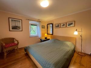 a bedroom with a bed and a chair and a window at Appartement près de DOLE in Menotey