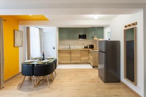 a kitchen and dining room with a table and a refrigerator at La promesse - T2 Hyper centre in Abbeville