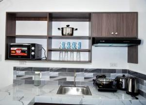 a kitchen counter with a sink and a microwave at Casa Bugambilia Door 2 in Balamban