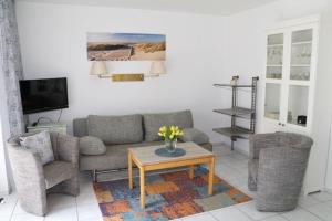 a living room with a couch and two chairs and a table at Appartement 5 in Scharbeutz