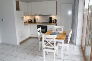 a kitchen with a wooden table and white cabinets at Appartement 5 in Scharbeutz
