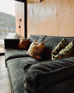 a couch with pillows on it in a living room at Naturlodges Edersee - Lodge #1 in Edertal +12 photos