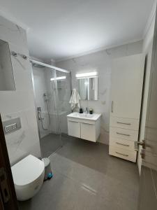 a bathroom with a toilet and a shower and a sink at Su Apartment Side in Side +36 photos