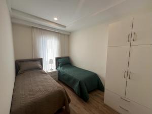 a small bedroom with a bed and a white cabinet at Su Apartment Side in Side