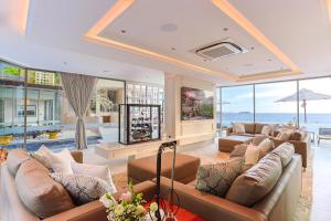 a large living room with couches and a pool at Villa W Collection in Nai Harn Beach