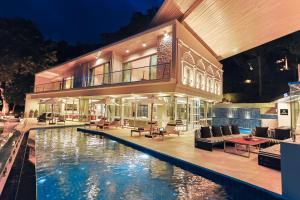 a house with a swimming pool in front of it at Villa W Collection in Nai Harn Beach