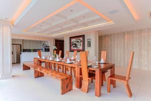 a dining room with a long wooden table and chairs at Villa W Collection in Nai Harn Beach