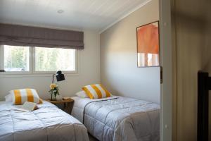 a bedroom with two beds and a window at Alppinotko Runne Lumo Hosted ny Hygge Host in Himos