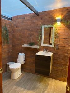 a bathroom with a toilet and a sink at Cabañas Murmullos del arroyo in Choachí