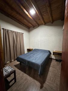 a bedroom with a bed with a blue comforter at Cabañas misueño in Villa Ciudad de America +21 photos