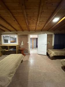 a large room with two beds and a door at Cabañas misueño in Villa Ciudad de America