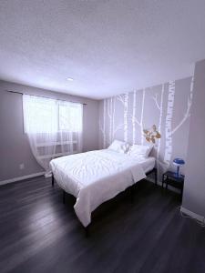 a bedroom with a bed with white sheets and a window at 4 Bedroom House steps to 401, Perfect for long stays in Belleville +18 photos