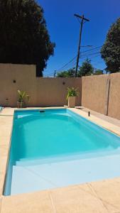 a large blue swimming pool in a backyard at Departamento Bita in Puerto Iguazú