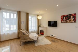 a living room with a chair and a tv at L'amour vrai - Love room -T2 Elégant et Romantique in Abbeville