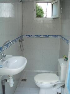 uma casa de banho com um lavatório, um WC e uma janela. em Villa Azaiiza em Sousse