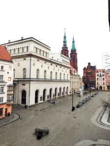 a large white building on a street in a city at Rynek Golden Stay by Grafit in Legnica