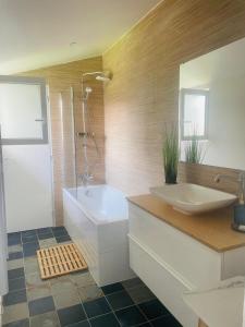 a bathroom with a tub and a sink and a shower at Cabane de Pénélope avec spa privé centre-ville et plage in Andernos-les-Bains