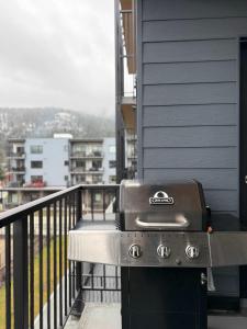 a grill on the balcony of a house at Revelstoke Marvel - Two Bedroom with Hot Tub in Revelstoke