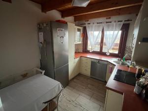 Una pequeña cocina con nevera y fregadero. en Cozy 5 room house, en Drienovská Nová Ves 5 fotos más
