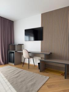 a living room with a desk and a tv at Marmotta Paltinis in Păltiniş