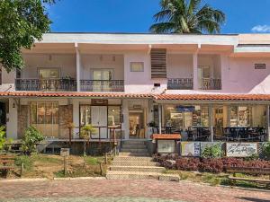 a house with a palm tree in front of it at Apartamento praça Morro de São Paulo in Cayru