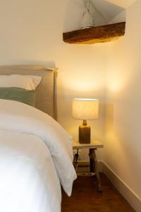 a bedroom with a bed and a table with a lamp at Au coeur de Marlotte in Bourron-Marlotte