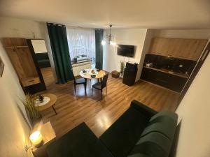 a living room with a green couch and a table at Apartament Mączyńskiego in Jarosław