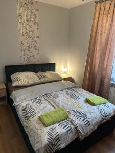 a bedroom with a bed with two green towels on it at Apartament Mączyńskiego in Jarosław