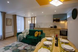 a living room with a green couch and a table at La promesse - T3 Hyper centre in Abbeville