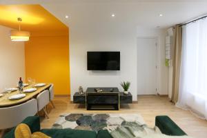 a living room with a couch and a tv on a wall at La promesse - T3 Hyper centre in Abbeville