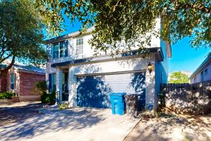 a house with a garage with a blue door at Living the Dream in San Antonio