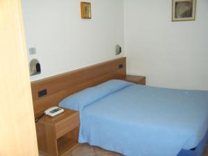 a small bedroom with a blue bed and a table at Residence Vezzoli in Boario Terme