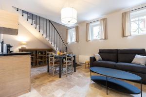 a living room with a couch and a table at Au coeur de Marlotte in Bourron-Marlotte +4 photos