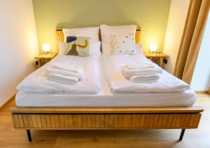 a large bed with white sheets and pillows on it at Pausenhof Spreewald in Unterspreewald