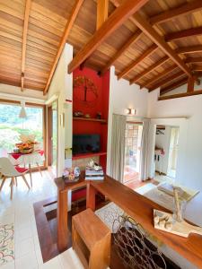 a living room with a wooden table and a dining room at Chalé nas montanhas em São Francisco Xavier in São Francisco Xavier +22 photos
