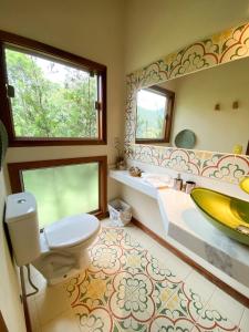 a bathroom with a sink and a toilet and a tub at Chalé nas montanhas em São Francisco Xavier in São Francisco Xavier